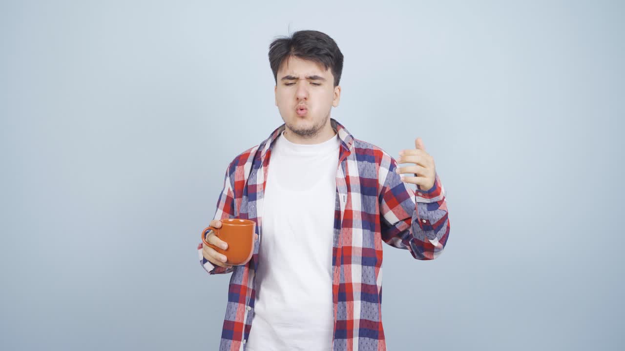 The man's mouth is burning from the hot drink.