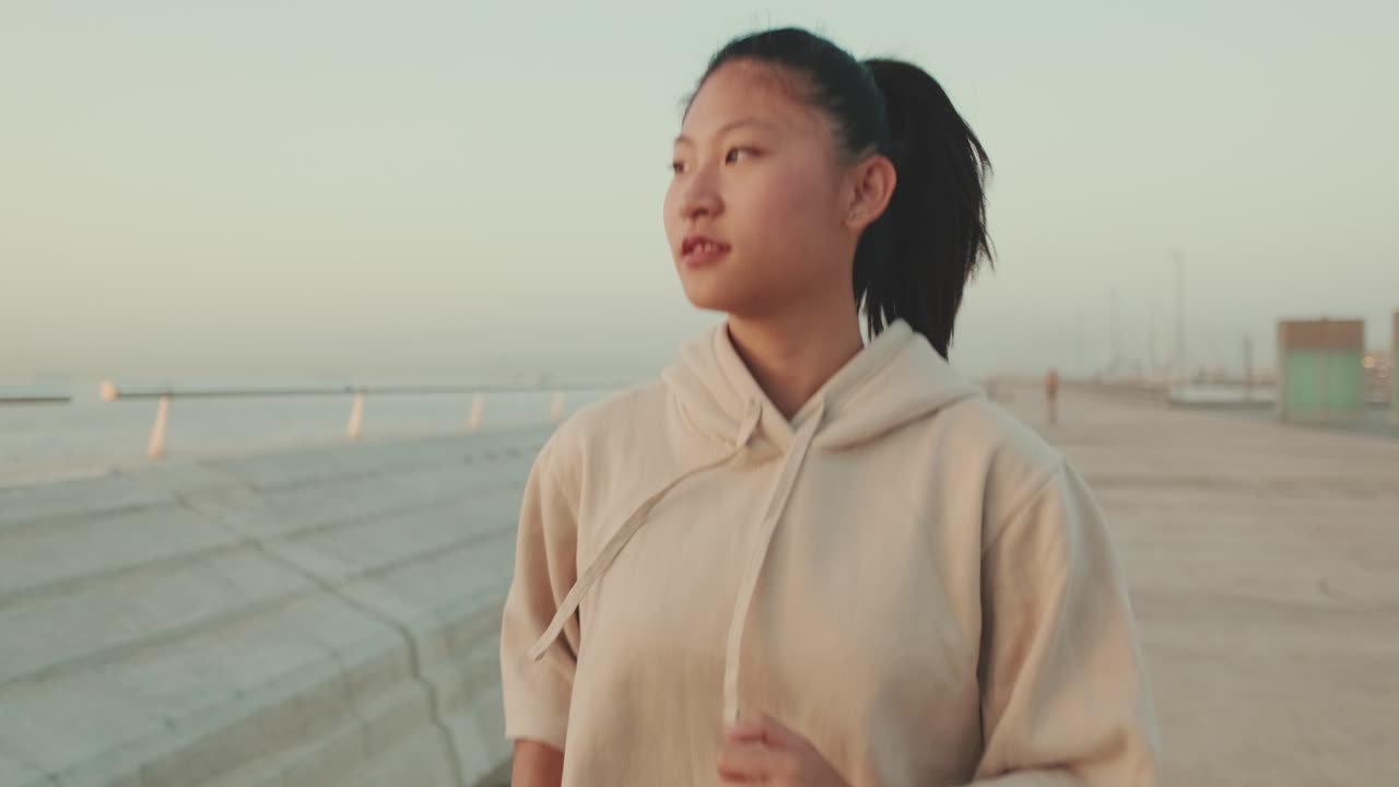 Woman in hoodie jogging outdoors
