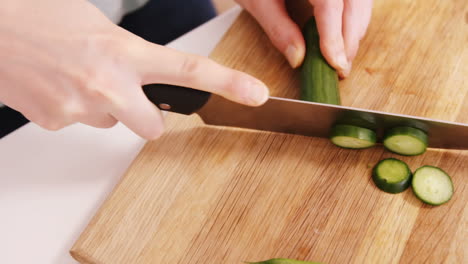 cerca de una mujer tallando un pepino