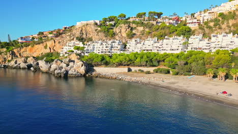 amazing aerial drone shot over beachside resort along playa marina del este beach, spain on a sunny day