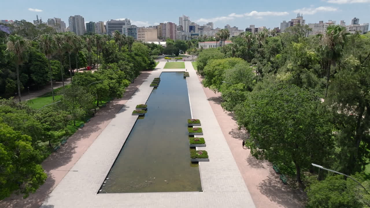 Vista aérea con dron sobrevolando la fuente y el espejo de agua en el Parque da Redenção (Parque da Redencao) en Porto Alegre, Brasil. Vídeos en 4K ProRes de 10 bits