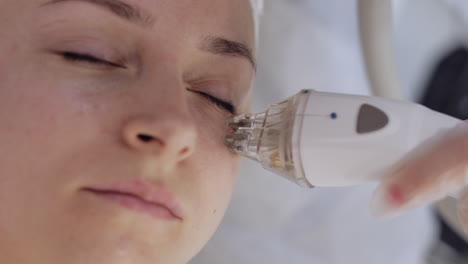 esteticista hace a la mujer rf lifting procedimiento de cosmetología de la cara y los ojos mascarilla de colágeno en el spa