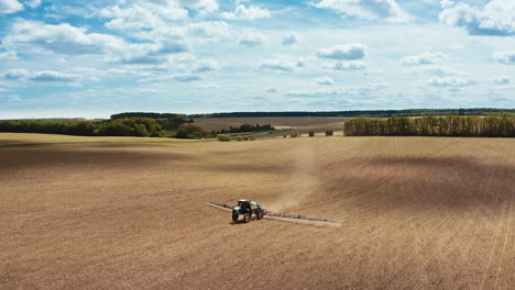 modern technology of agriculture. aerial view of the tractor spraying the chemicals on large field