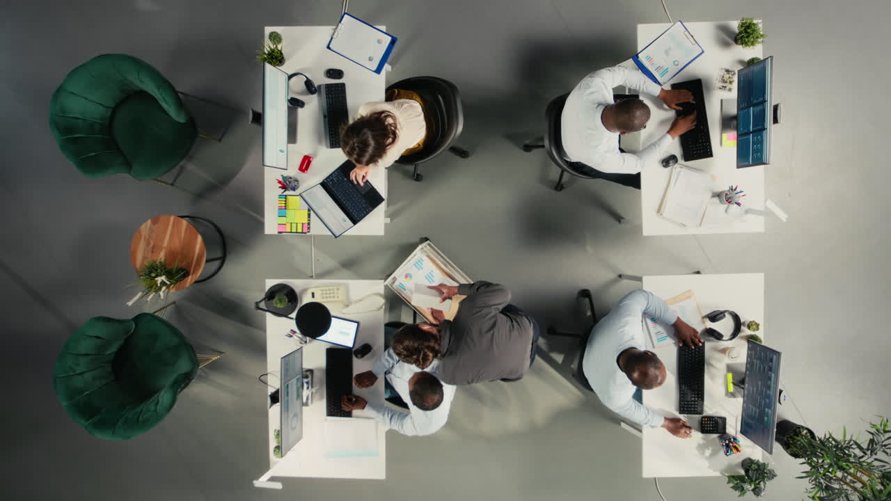 Vertical Video Top down view of employees reviewing charts and diagrams during briefing