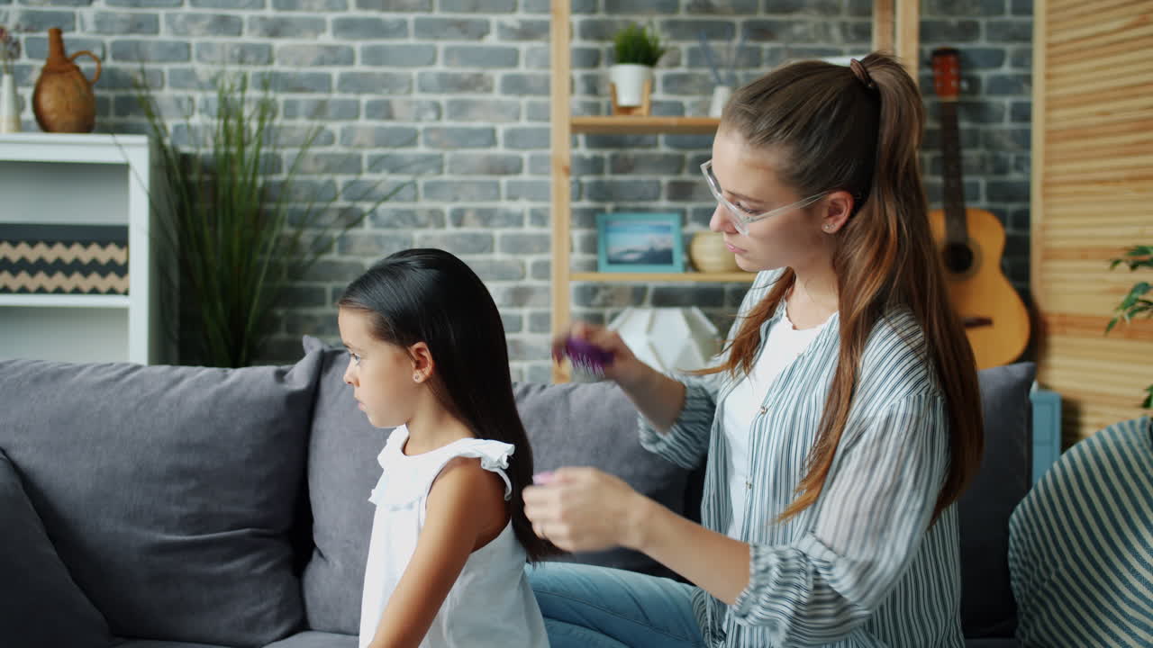 Madre che spazzola i capelli di sua figlia
