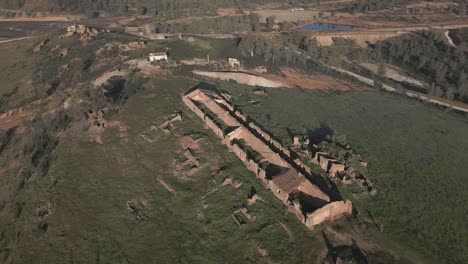 Aerial-view-on-ruin-of-house-located-on-green-hill