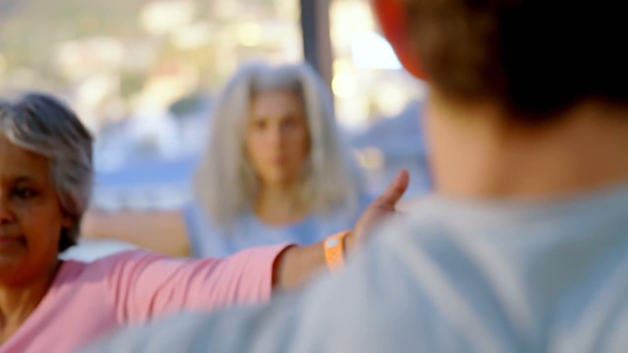 Træner hjælper ældre kvinder med at udføre yoga 4k