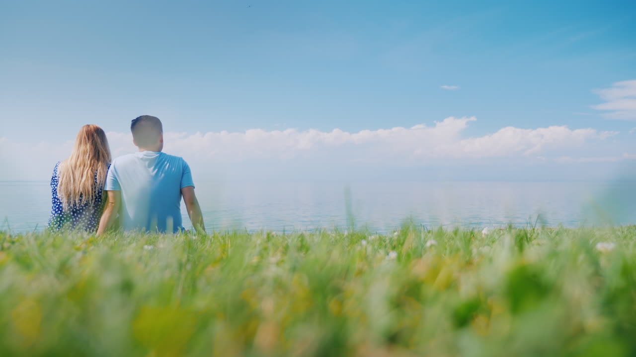 아름다운 자연을 감상하며 푸른 잔디에서 쉬고 있는 다민족 커플