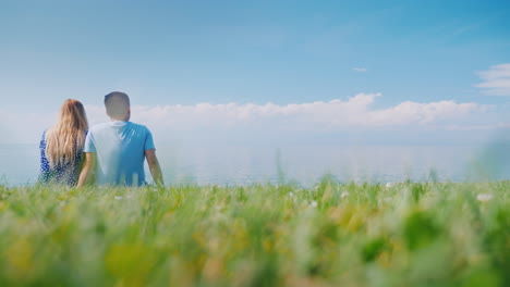 multi-ethnic couple resting on the green grass admiring the beautiful nature