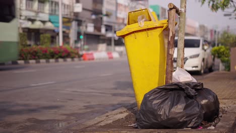 yellow trash can on city street
