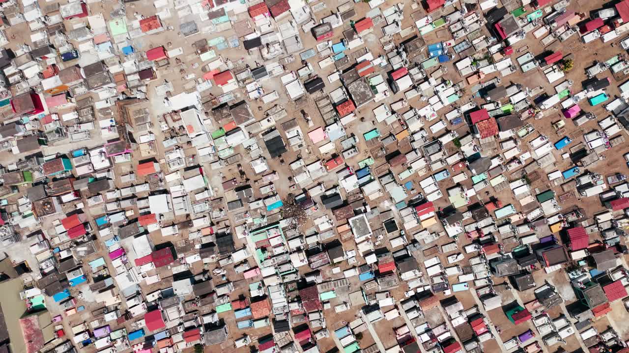 Colorful tombs and graves in a traditional mexican cemetery seen from a high aerial perspective