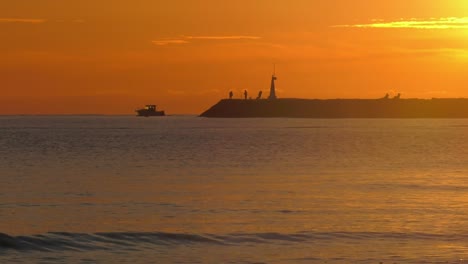 barco de motor saliendo del puerto al amanecer, silueta a cámara lenta