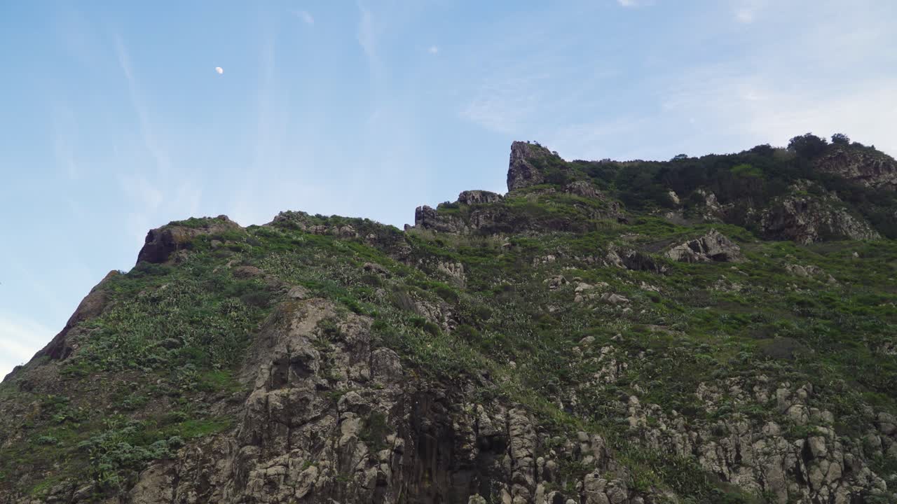 Sunset over a mountain with the moon on the background, Santana, Madeira island, Portugal.