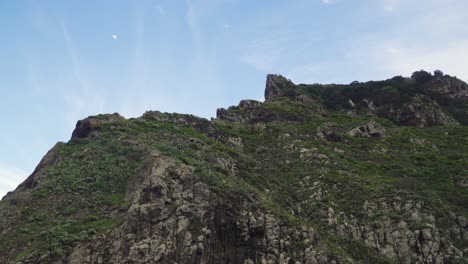 sunset over a mountain with the moon on the background, santana, madeira island, portugal.