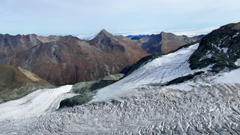 Saas-Fee-Saastal-glacier-ski-resort-rotating-restaurant-Switzerland-Swiss-Alps-Alpine-Valley-glacial-peaks-summer-autumn-fall-Zermatt-Platen-Alphabet-Taschorn-dirty-snow-sunny-blue-sky-slow-pan-left