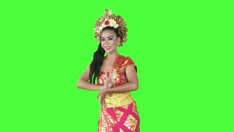 balinese dancer smiling at camera while dancing