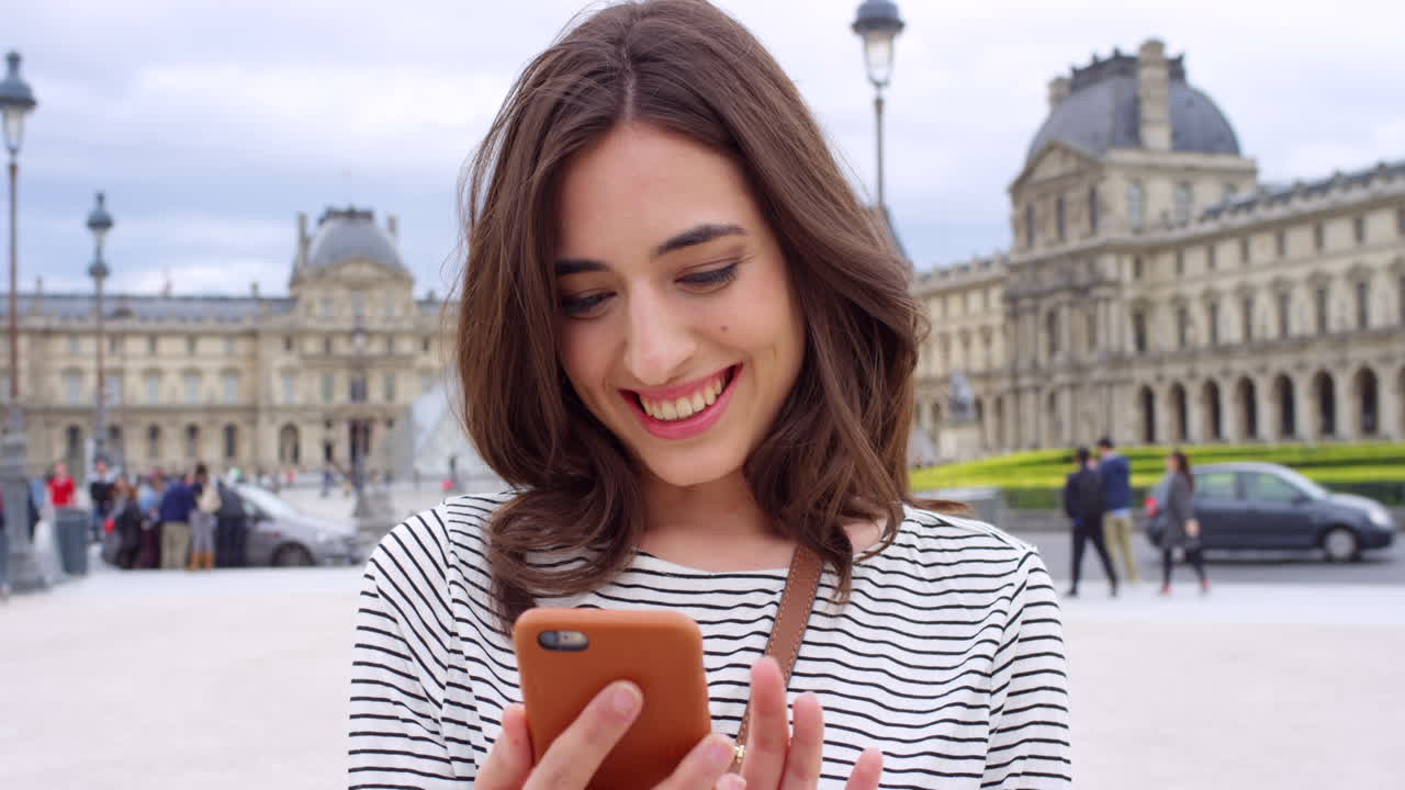 Mulher usando o telefone em frente ao Museu do Louvre em Paris
