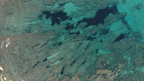 Luftaufnahme-Von-Kristallklarem,-Blauem-Wasser-In-Der-Nähe-Eines-Der-Strände-Der-Insel-Sardinien