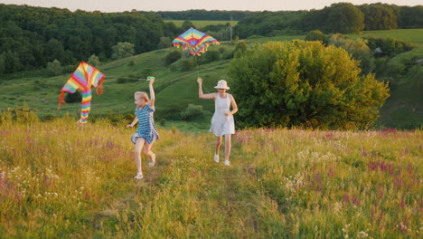 A-Young-Mother-With-A-Girl-With-Two-Pigtails-Resting-In-Nature-Playing-With-An-Air-Kite