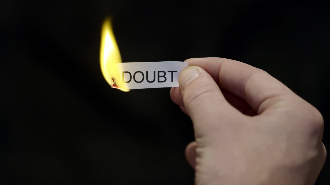 Burning Away Doubt - Hand Setting Fire to Paper note Marked “DOUBT”, Powerful Release of Criticism, Guilt and Shame, Dark Cinematic Close-Up. Mental health, therapy