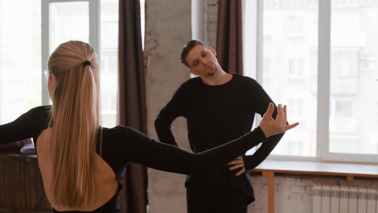 Two dancers practicing their routine in a spacious studio