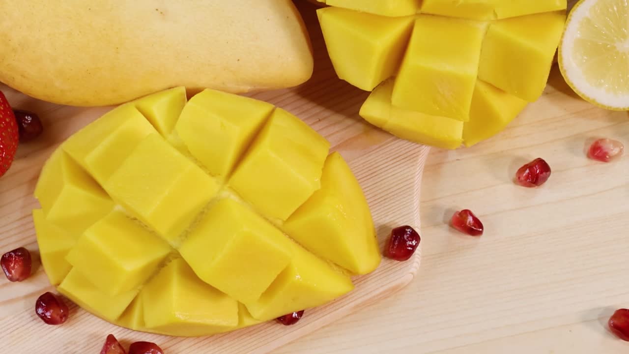 A colorful arrangement featuring ripe mangoes, kiwis, bananas, strawberries, and citrus slices.