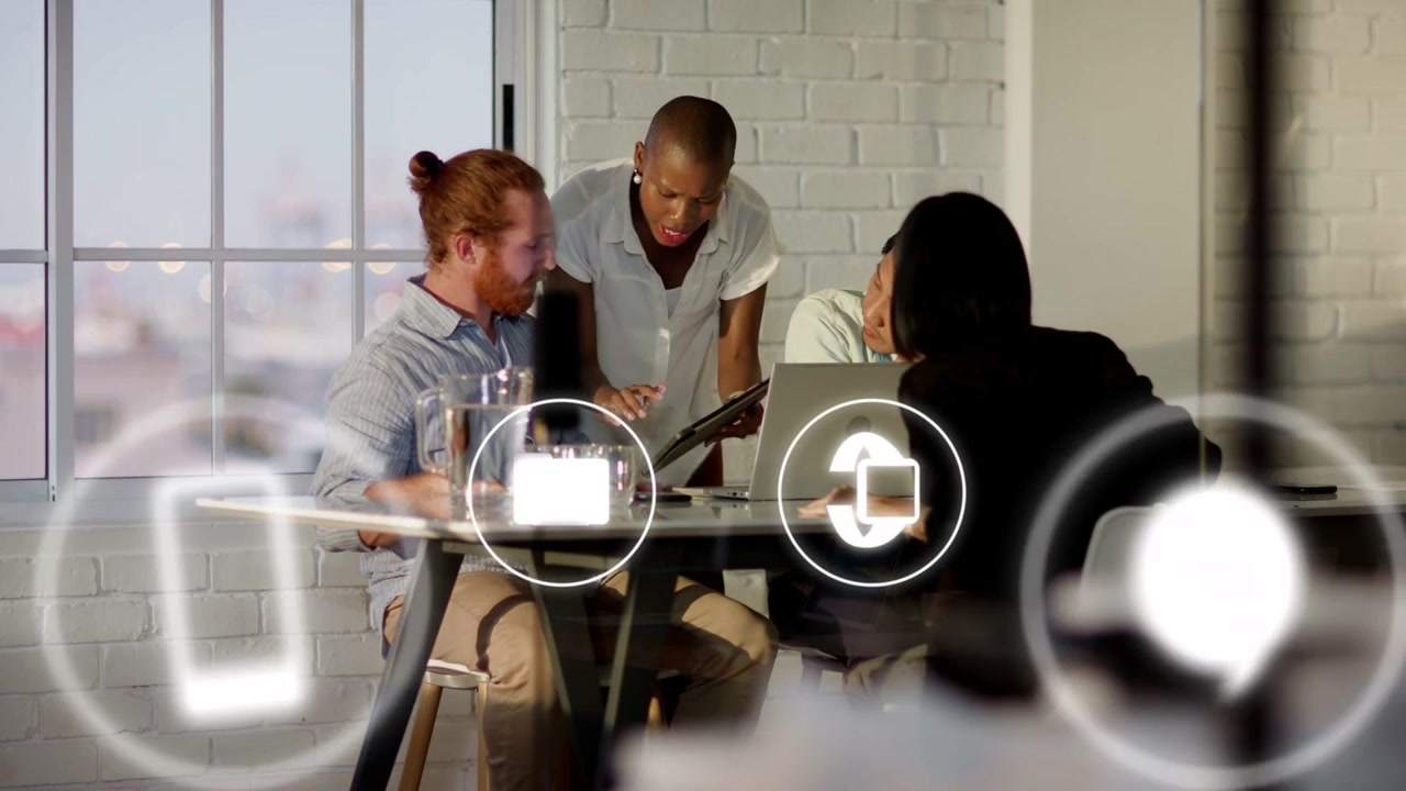 Woman entering with tablet, presenting tablet to team at laptop, UI icons showing business data