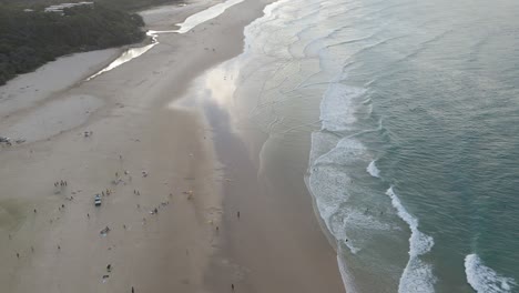 Fliegen-In-Richtung-Sandstrand-Mit-Touristen,-Die-Sommerferien-Am-Zylinderstrand-Auf-North-Stradbroke-Island,-Australien,-Genießen