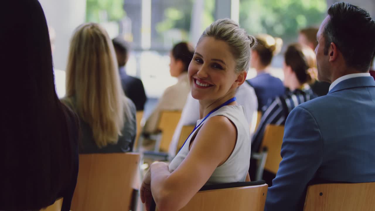 Businesswoman looking at camera during seminar 4k