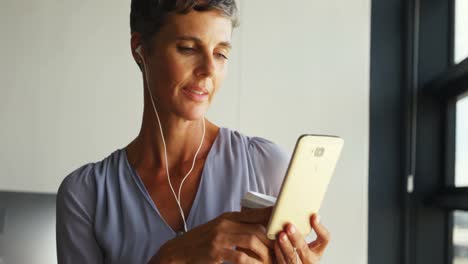 mujer de negocios tomando café mientras escucha música en el teléfono móvil 4k