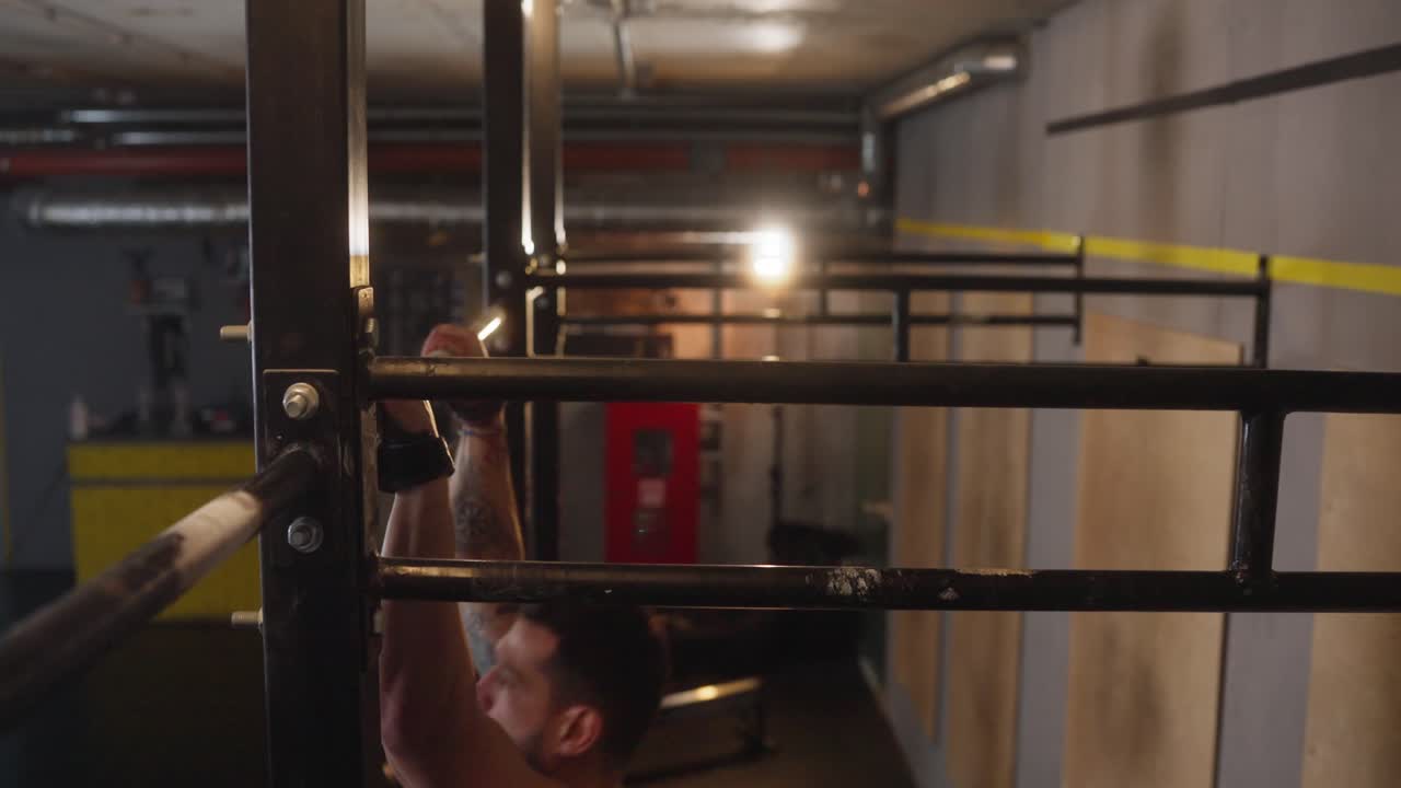 Man exercising on pull-up bar in gym