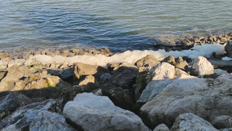 Dangerous-sea-foam-on-the-rocky-shoreline--wide