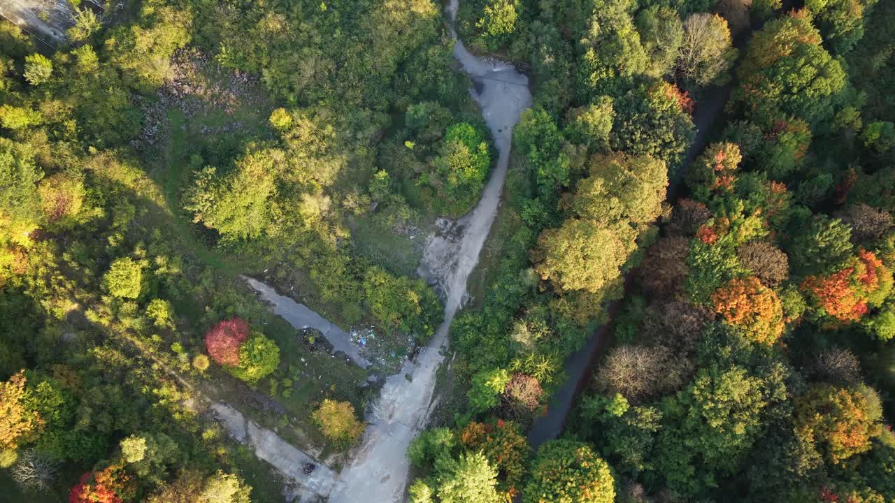 Sheffield Ski Village lies in ruins, with dirt paths, broken infrastructure, and autumn-colored forest overtaking the slopes, as nature reclaims the site once home to Europe’s largest dry ski resort