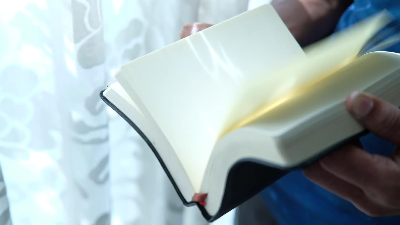 검은 책을 들고 읽는 사람