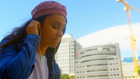 Young-woman-listening-music-on-headphones-in-the-city-4k