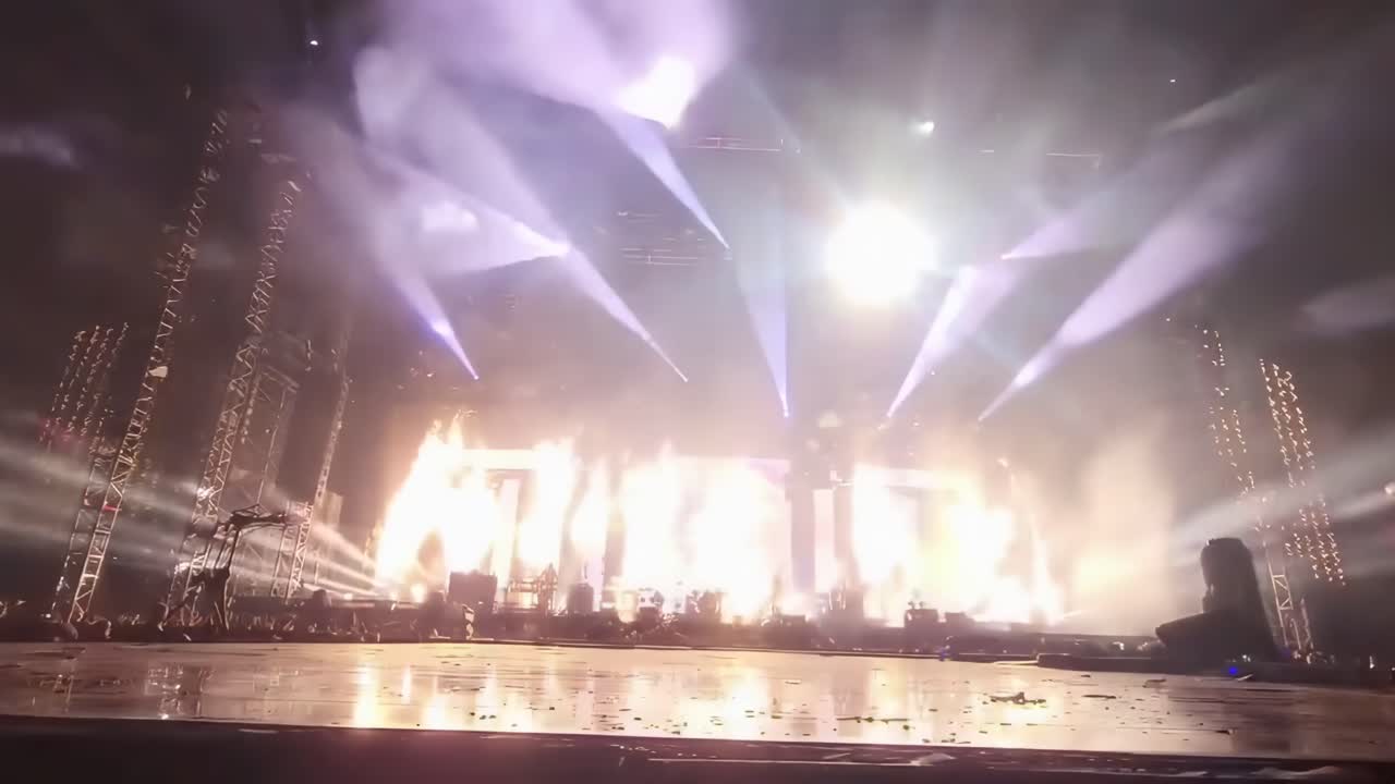 Dynamisk lavvinkel video af en levende koncertscene med farverige lys og silhuetter