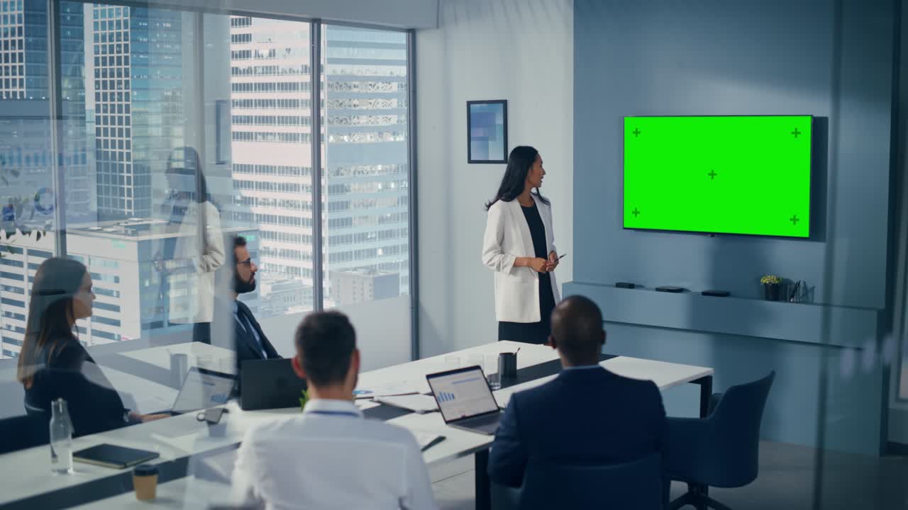 Diverse Office Conference Room Meeting: Successful Asian Businesswoman Talks, Uses Green Screen Chroma Key Wall TV for Presenting Product to Group of Investors. e-Commerce Strategy. Wide Shot