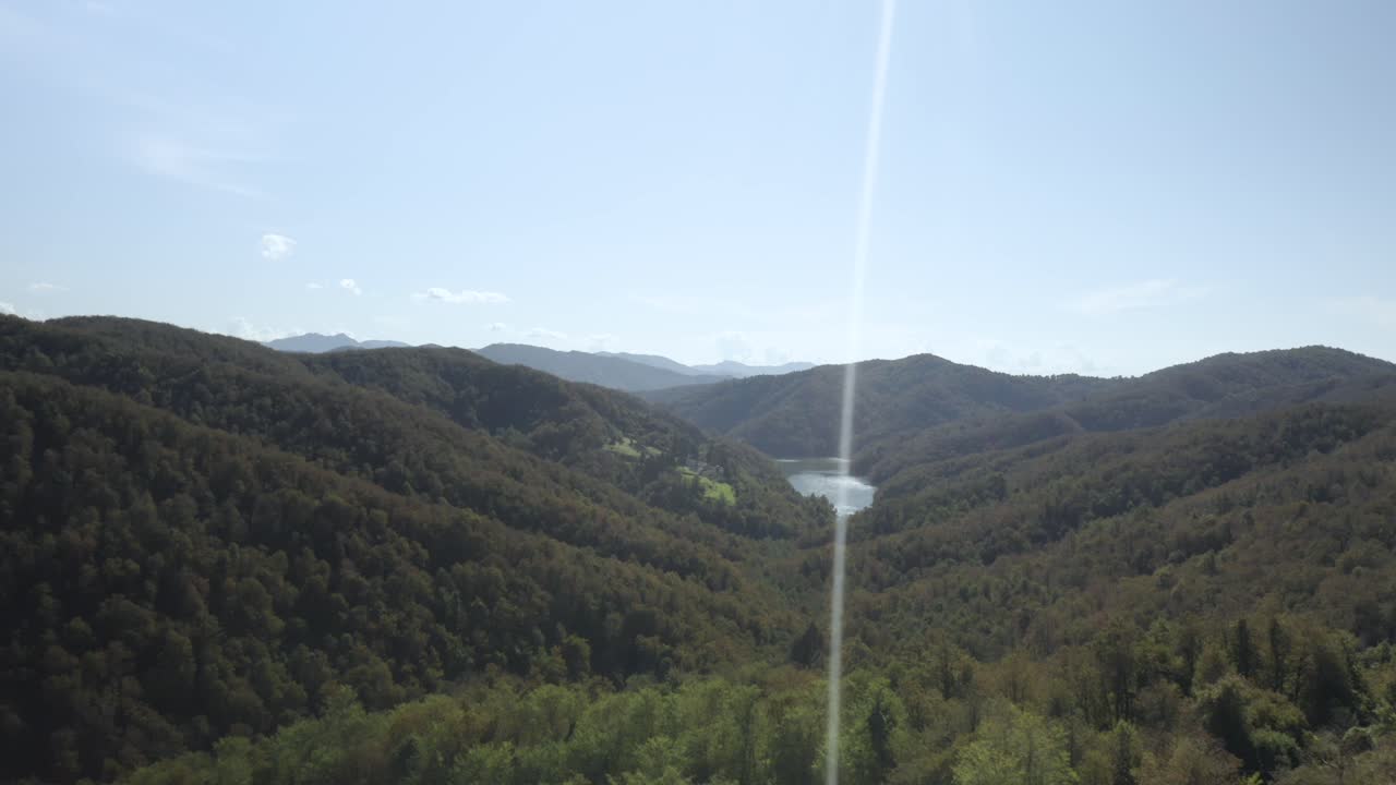 Aerial view of a lake through some mountains in Italy