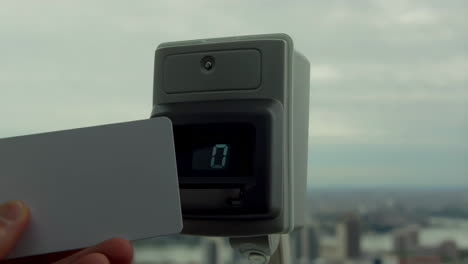 person using an access card with a card reader against a cityscape background