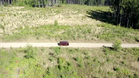 vw van vintage van driving through forest aerial view 4k drone