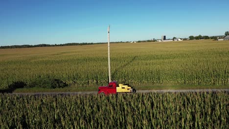 Camión-Rojo-Vintage-Conduciendo-A-Través-De-Campos-De-Maíz-Seguimiento-Lateral-Aéreo