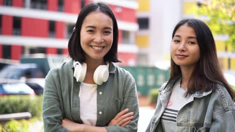 通りでカメラに笑顔とポーズをとる 2 人の美しい日本の若い女の子の屋外のポートレート