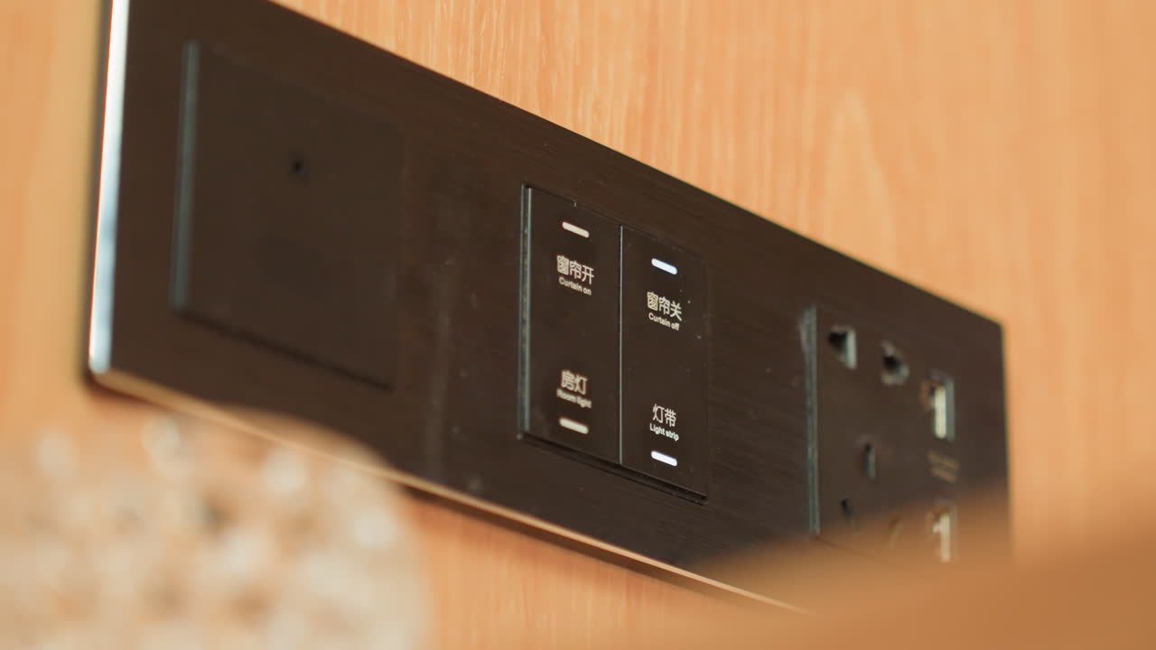 Guest adjusts controls. Guest interacts with bedside touch controls for lighting devices. Contemporary hotel room amenities featuring touchscreen controls for lighting and charging options