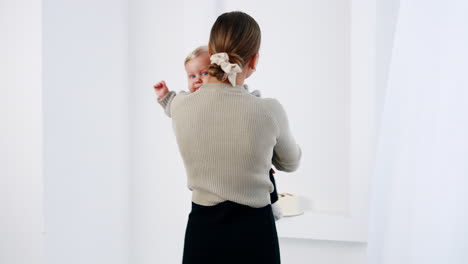 happy motherhood. caucasian woman holding her son, circling with him and kissing with love. white backdrop.