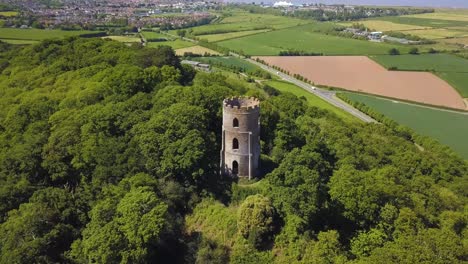 aerial view of the dunster conygar tower and surrounding areas full of trees near dunster castle, somerset, england.