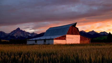rustic barn with mountain backdrop at sunset
