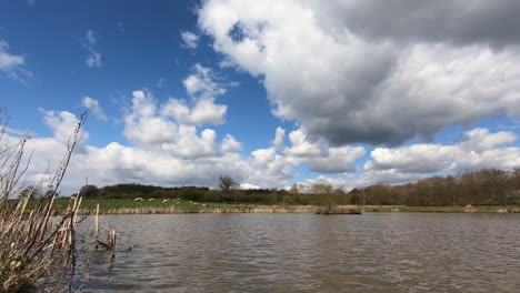 Las-Nubes-Blancas-Pasan-Por-Encima-De-La-Cabeza-En-Una-Piscina-De-Pesca-De-Truchas-Artificial-En-Worcestershire,-Inglaterra,-Reino-Unido.