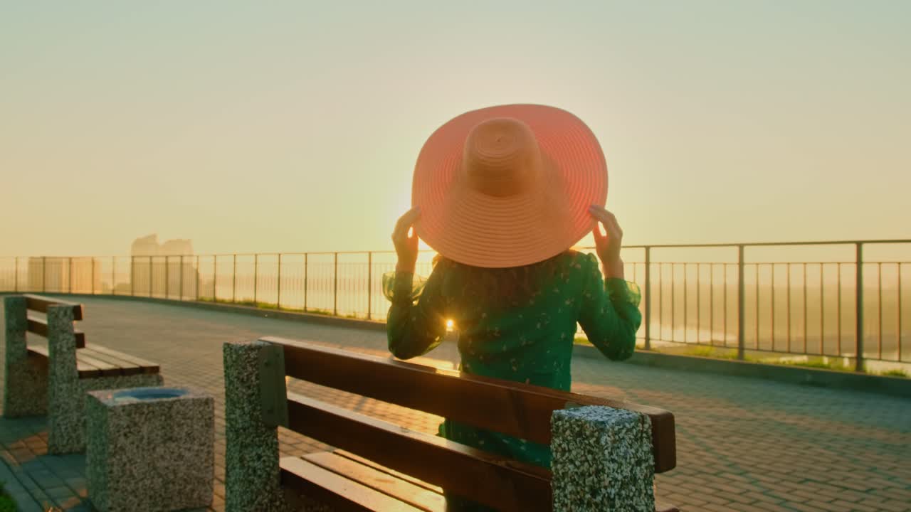 Woman enjoying the Sunrise from a Park Bench