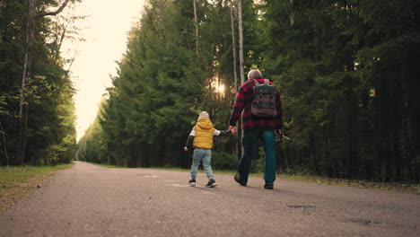 un niño feliz y su abuelo están caminando a pescar en primavera o otoño por la mañana pasando el fin de semana juntos