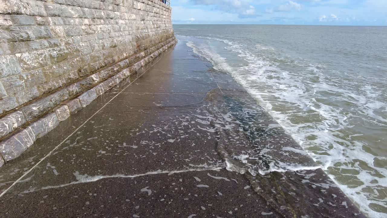 olas que se elevan sobre la estructura de la pared del rompeolas en teignmouth devon, inglaterra